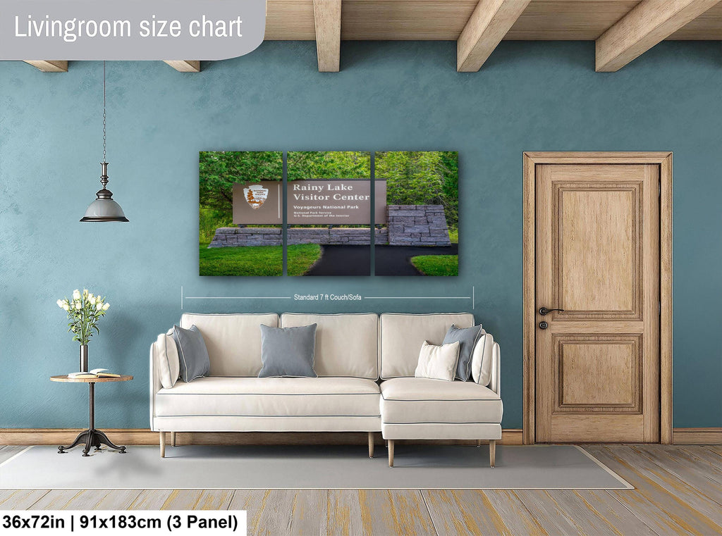 Living room with a large Rainy Lake Visitor Center Sign wall art piece and a sofa.