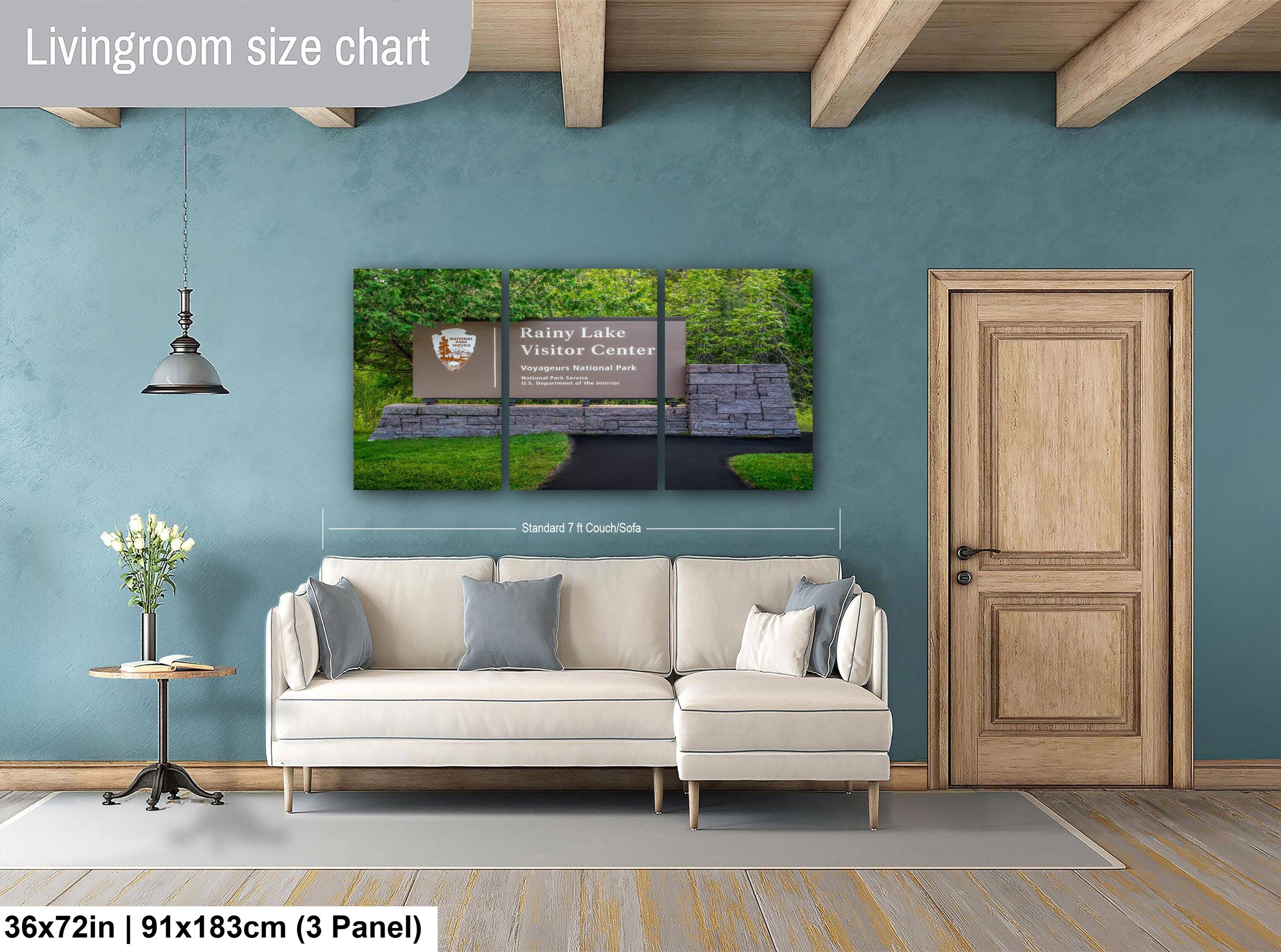 Living room with a large Rainy Lake Visitor Center Sign wall art piece and a sofa.