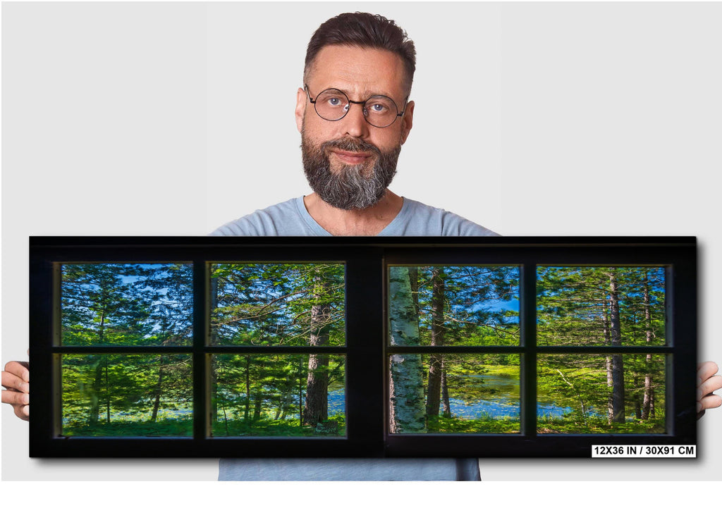 Man holding a large framed picture of a forest
