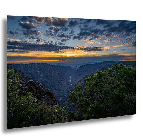 Sunrise over Black Canyon of the Gunnison, Colorado, with glowing cliffs and a shimmering river below.