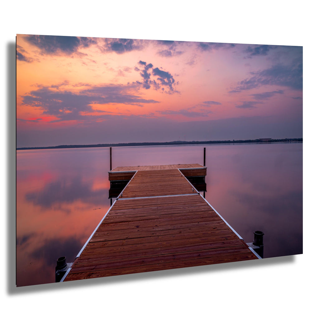 Sunset over calm Lake Bemidji with dock view and pastel skies before a summer storm.