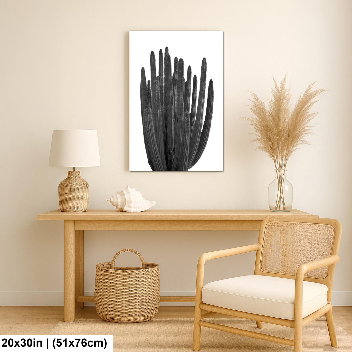 Black and white wall art print of an organ pipe cactus with tall vertical arms and ribbed detail in a nautical-themed room with a wooden table, wicker chair, and decorative items.