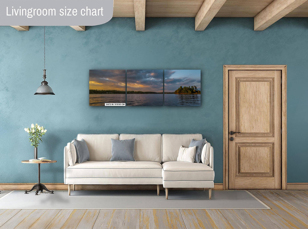 Living room with a sectional sofa, side table, and wall art depicting a sunset over water.