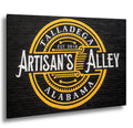 Artisan’s Alley mural in Talladega, Alabama, painted in gold and white on a black brick wall.