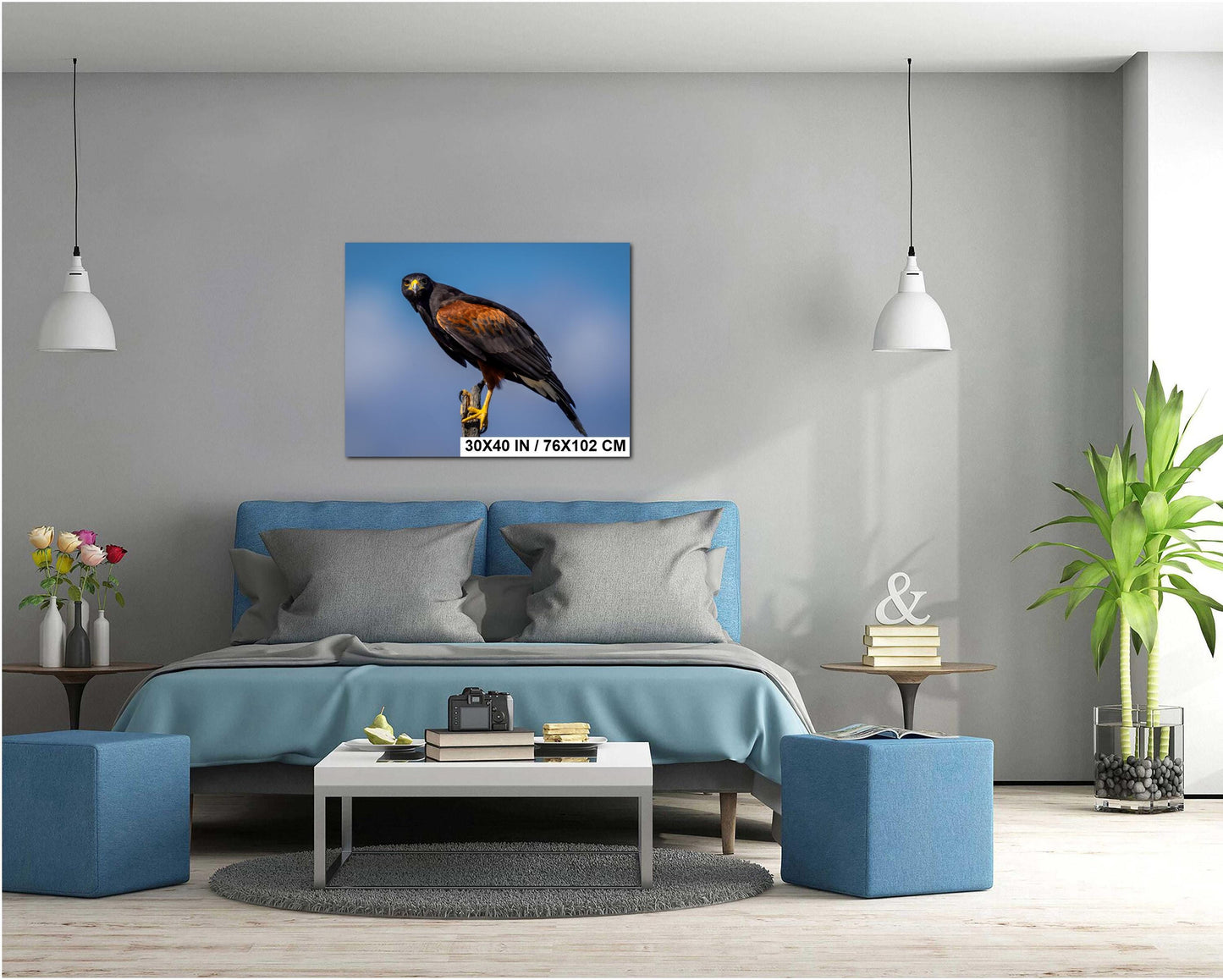 Living room with a blue sofa, coffee table, and decorative items, featuring Harris’s hawk on desert branch wall art ptint.