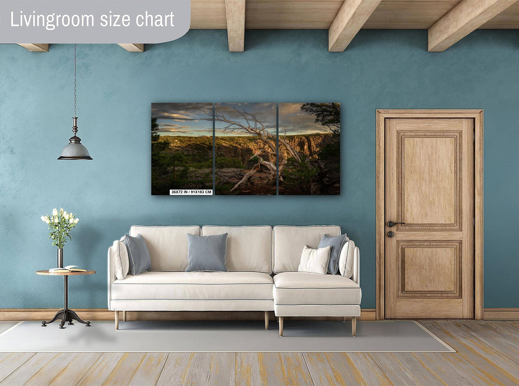Living room with a sectional sofa, side table, and wall art on a blue wall.