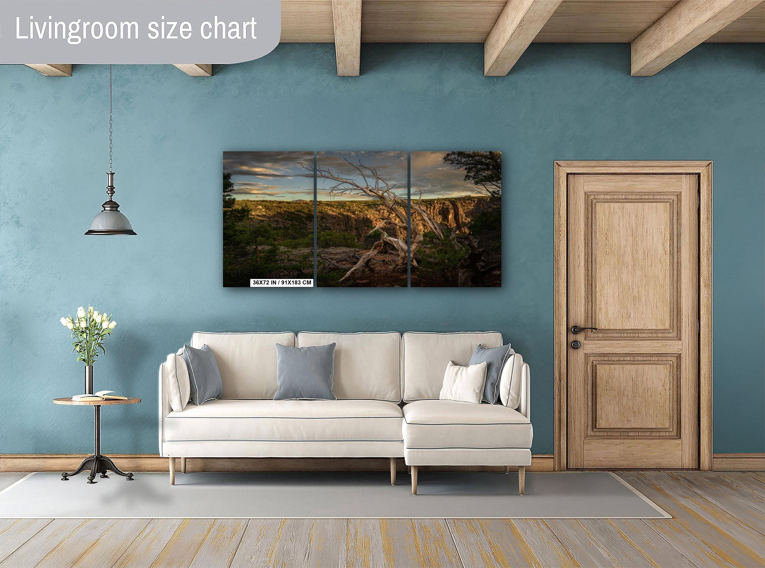 Living room with a sectional sofa, side table, and wall art on a blue wall.