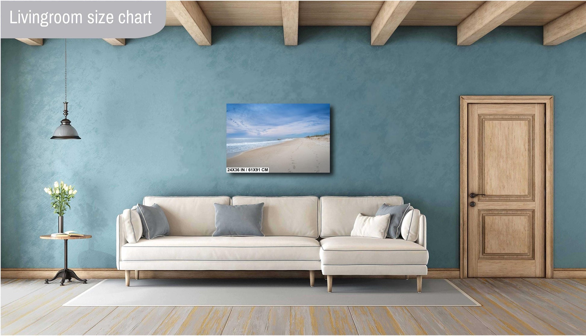 Minimalist living room featuring a 24x36 beach photography canvas print centered above a white sectional sofa.