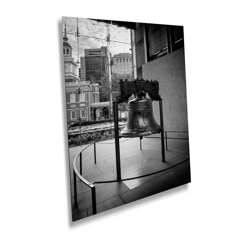 A black and white photograph of the Liberty Bell in Philadelphia, displayed as a wall art print with a glass frame and a metal/acrylic structure.