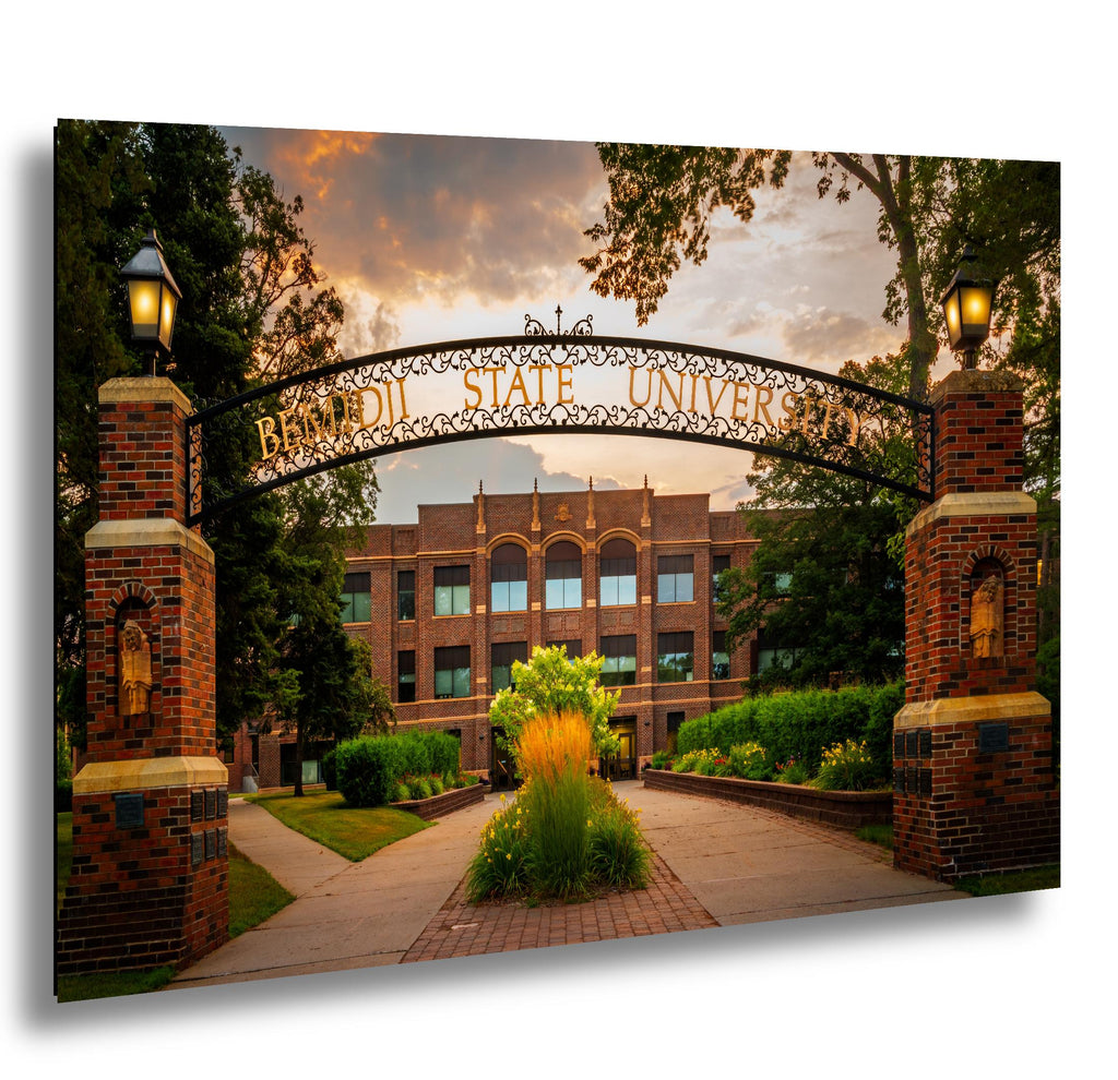 Bemidji State University ornate entrance arch with brick pillars at sunset.