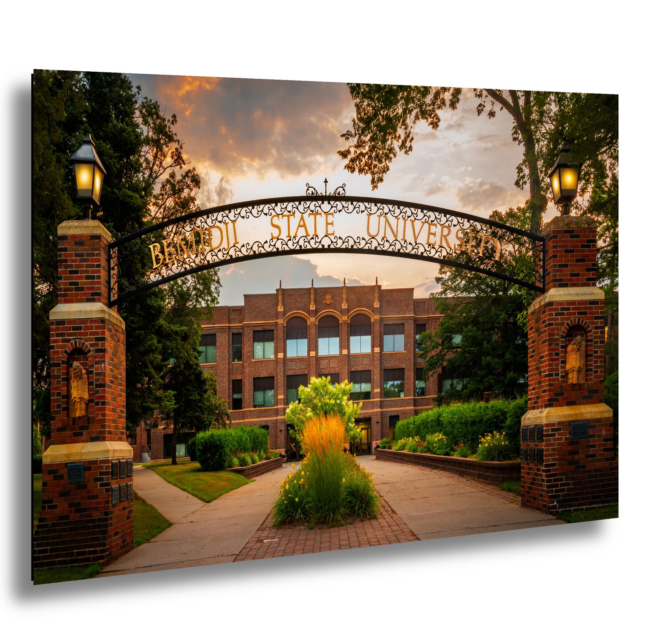 Bemidji State University ornate entrance arch with brick pillars at sunset.
