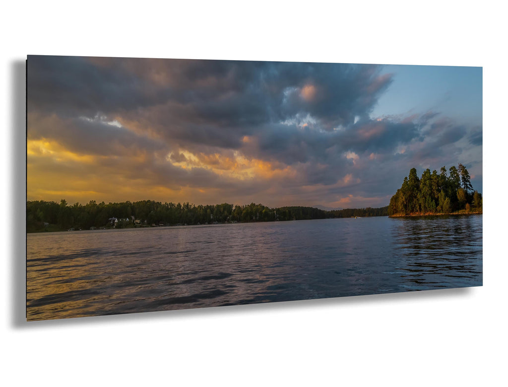 Scenic view of a lake with trees and a colorful sky.