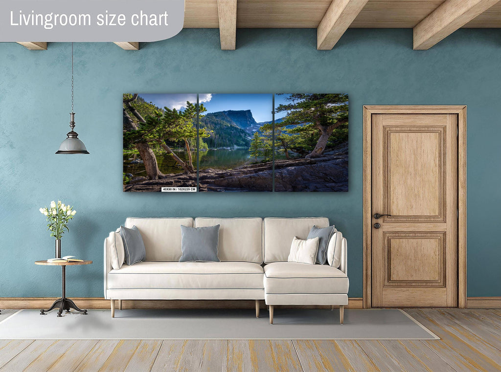 Living room with a large TV displaying a nature scene, beige sofa, and wooden door.