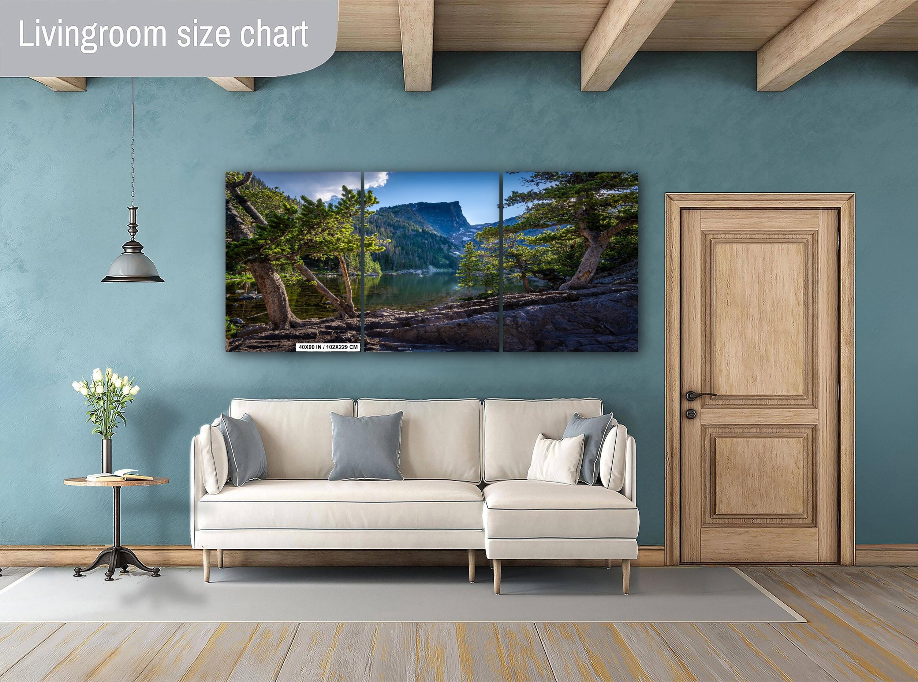Living room with a large TV displaying a nature scene, beige sofa, and wooden door.
