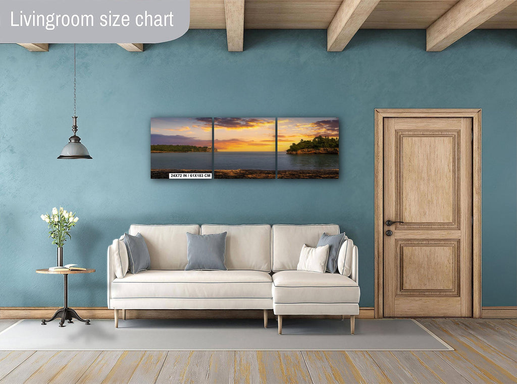 Living room with a beige sectional sofa, side table, and wall art depicting a sunset over water.