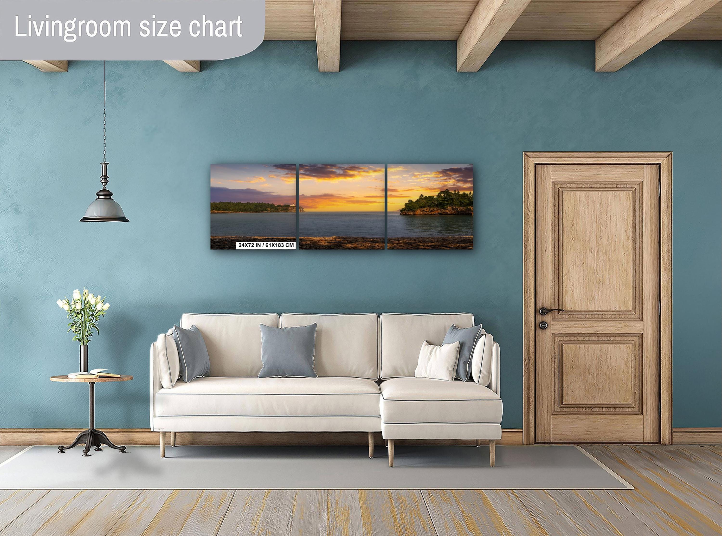 Living room with a beige sectional sofa, side table, and wall art depicting a sunset over water.