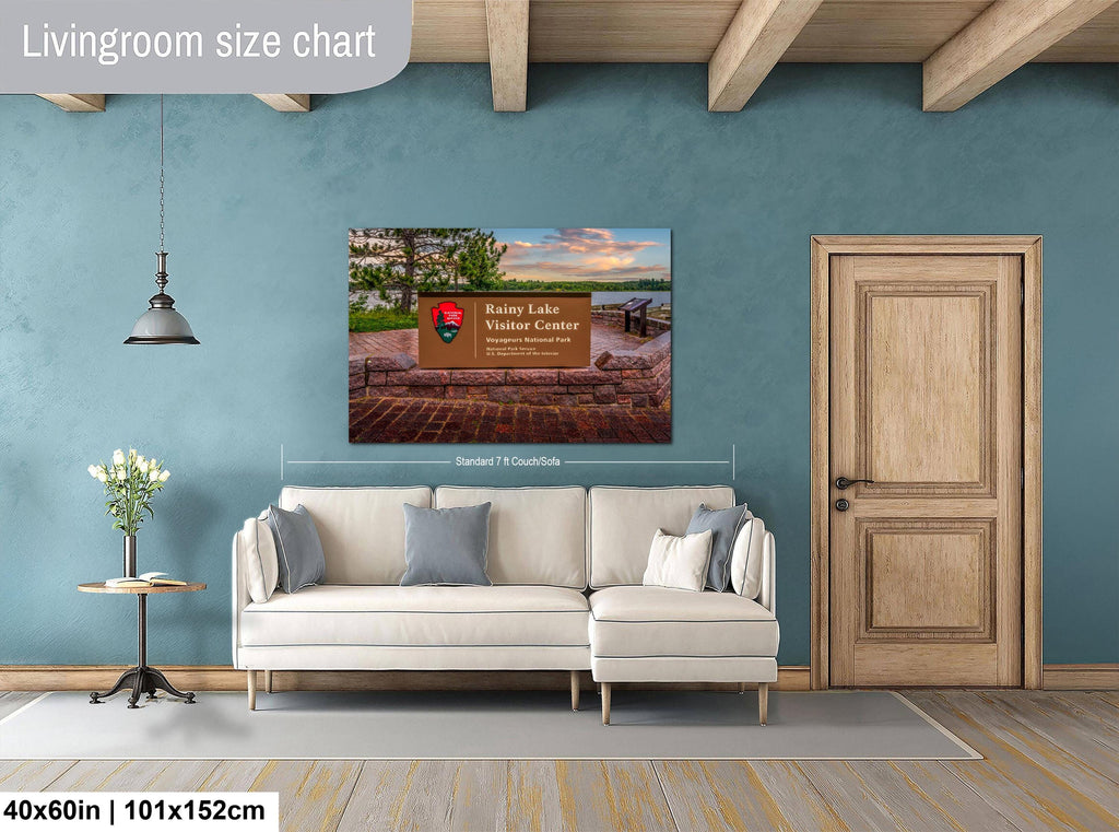 Living room with a wall art displaying a scenic view, beige sofa, and wooden door.