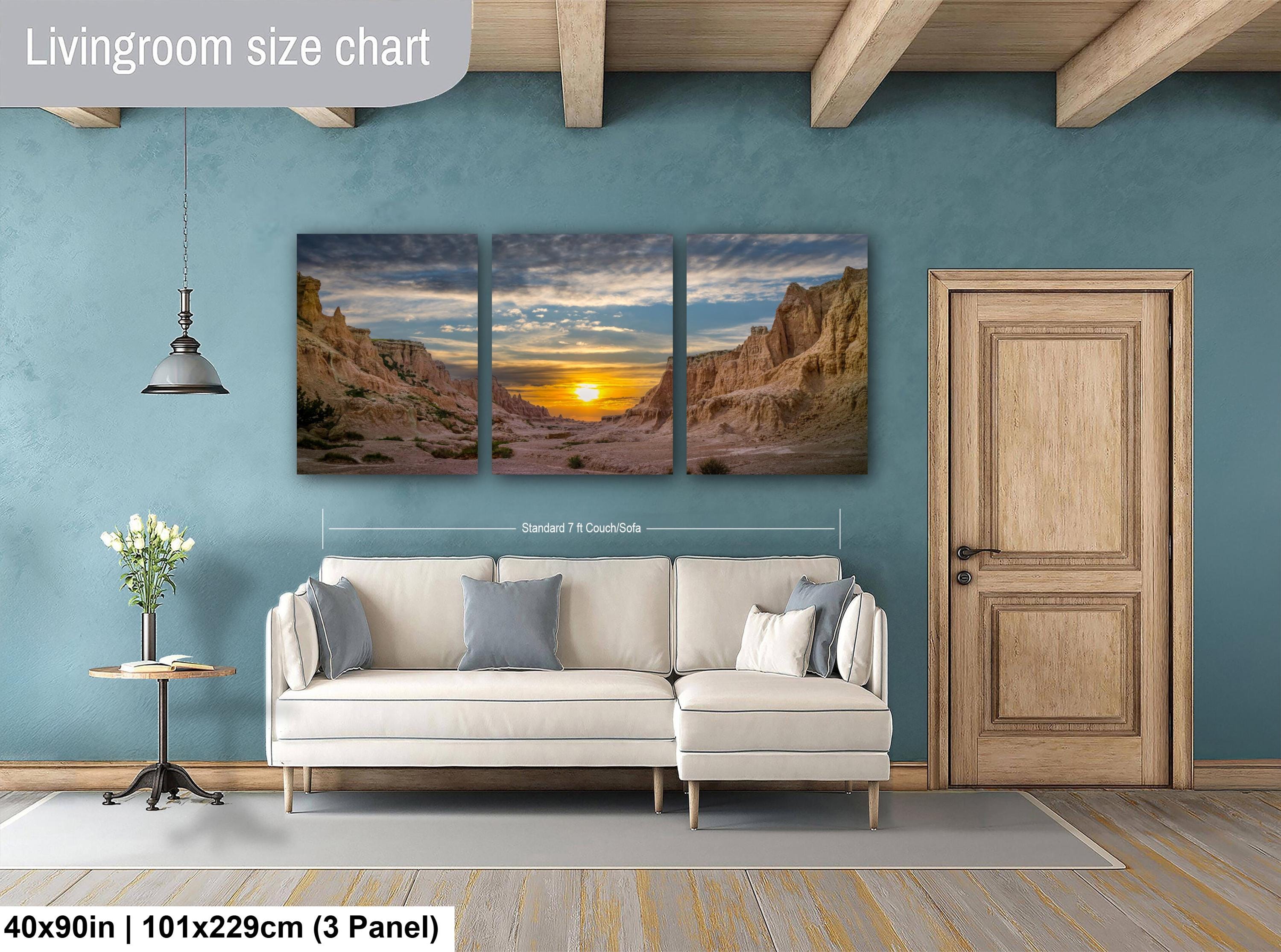 Living room with a beige sofa, side table, and wall art depicting a sunset over a desert landscape.