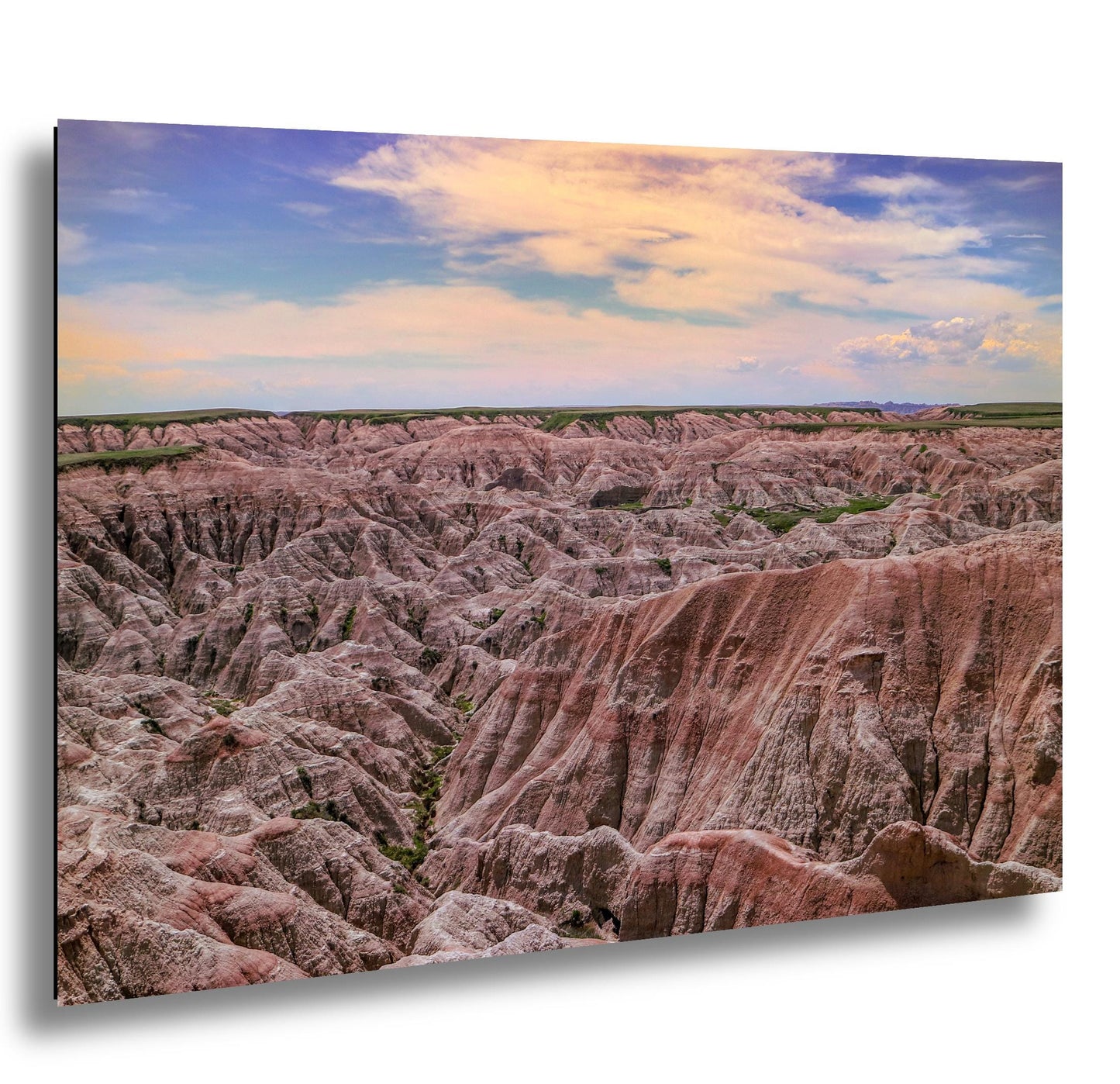 Badlands National Park pink rock formations at sunset under a pastel sky.