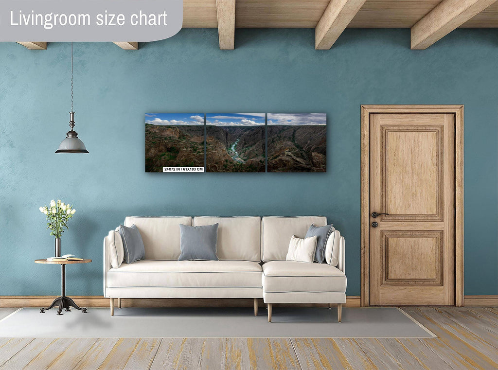 Living room with a beige sofa, decorative pillows, a side table with a plant, and a large wall art piece.
